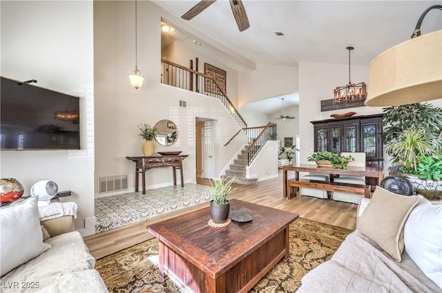 3324 Canyon Lake Dr, Las Vegas, NV 89117 - living area featuring a ceiling fan, stairs, wood finished floors, high vaulted ceiling, and a chandelier