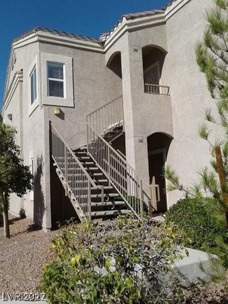 9470 Peace Way Unit 206, Las Vegas, NV 89147 - view of front of home featuring stairway, stucco siding, and a tile roof