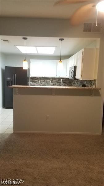9470 Peace Way Unit 206, Las Vegas, NV 89147 - kitchen featuring stainless steel microwave, fridge with ice dispenser, pendant lighting, tasteful backsplash, and light colored carpet