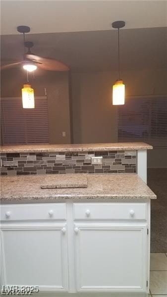 9470 Peace Way Unit 206, Las Vegas, NV 89147 - kitchen with white cabinetry, light stone countertops, a ceiling fan, and pendant lighting