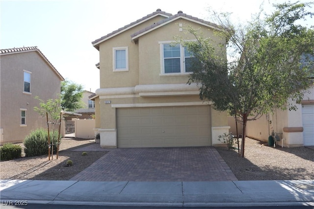 3237 Aiken St, North Las Vegas, NV 89032 - view of front of house featuring stucco siding, an attached garage, and decorative driveway