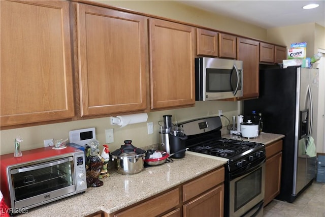 3237 Aiken St, North Las Vegas, NV 89032 - kitchen featuring stainless steel appliances, light stone countertops, brown cabinets, and recessed lighting