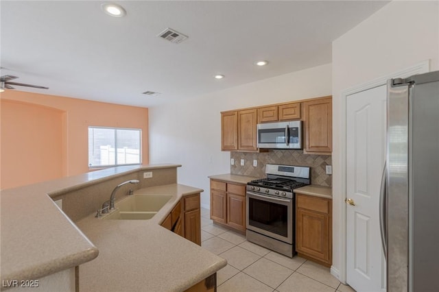 4855 Double Down Dr Unit 103, Las Vegas, NV 89122 - kitchen with appliances with stainless steel finishes, decorative backsplash, light countertops, light tile patterned floors, and brown cabinets