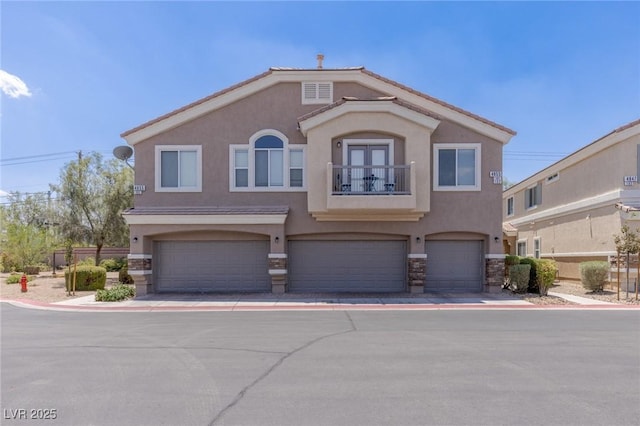 4855 Double Down Dr Unit 103, Las Vegas, NV 89122 - view of front of house featuring a balcony, stucco siding, an attached garage, and stone siding