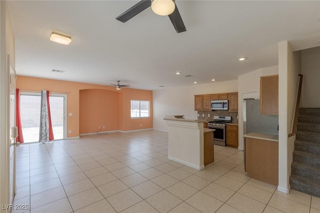 4855 Double Down Dr Unit 103, Las Vegas, NV 89122 - kitchen featuring a ceiling fan, appliances with stainless steel finishes, backsplash, open floor plan, and light countertops