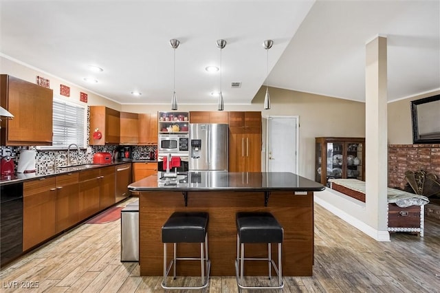 4544 Plaza De Vista St, Las Vegas, NV 89120 - kitchen with stainless steel appliances, dark countertops, a breakfast bar area, and brown cabinets