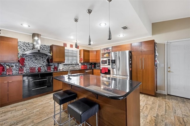 4544 Plaza De Vista St, Las Vegas, NV 89120 - kitchen with appliances with stainless steel finishes, wall chimney exhaust hood, dark countertops, brown cabinetry, and recessed lighting