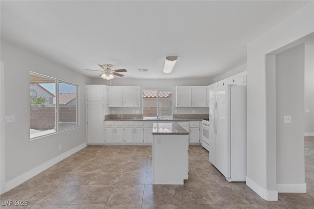 3664 Summer Picnic Ct, Las Vegas, NV 89147 - kitchen featuring white appliances, white cabinetry, a kitchen island, ceiling fan, and light tile patterned flooring