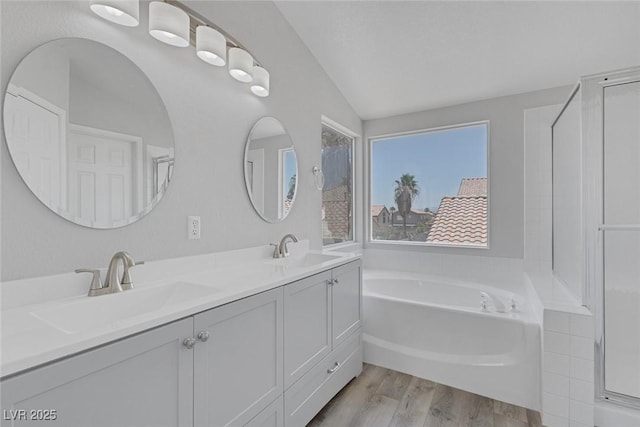 3664 Summer Picnic Ct, Las Vegas, NV 89147 - bathroom with vaulted ceiling, a bath, wood finished floors, and double vanity
