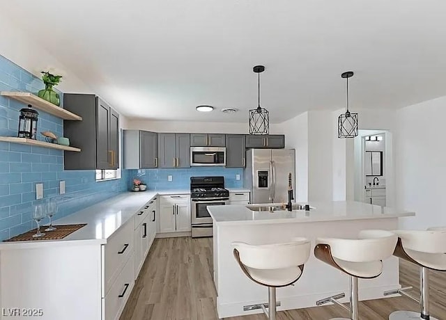 5321 Westleigh Ave, Las Vegas, NV 89146 - kitchen with appliances with stainless steel finishes, light wood-style flooring, and decorative backsplash