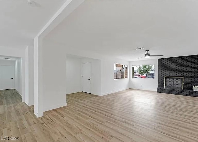 5321 Westleigh Ave, Las Vegas, NV 89146 - unfurnished living room featuring a ceiling fan, light wood finished floors, and a brick fireplace