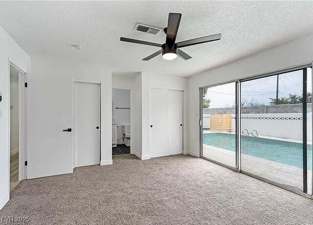 5321 Westleigh Ave, Las Vegas, NV 89146 - unfurnished bedroom featuring access to exterior, carpet flooring, a textured ceiling, connected bathroom, and ceiling fan
