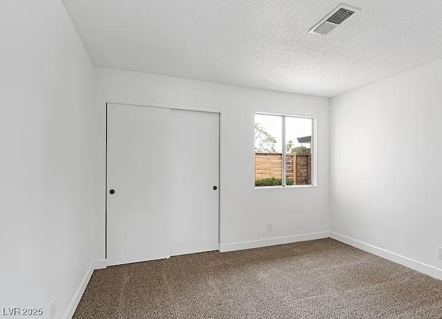 5321 Westleigh Ave, Las Vegas, NV 89146 - unfurnished bedroom featuring dark colored carpet, a closet, and a textured ceiling