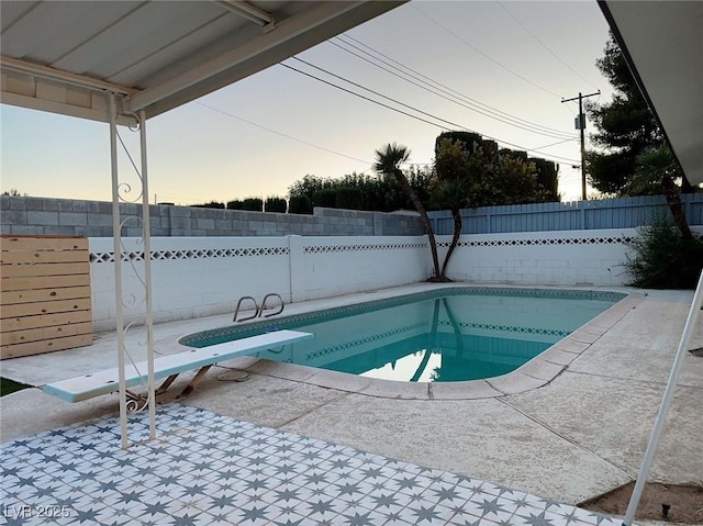 5321 Westleigh Ave, Las Vegas, NV 89146 - pool at dusk featuring a fenced backyard, a patio, and a diving board