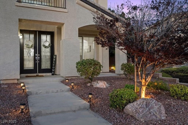 7012 Geese Gathering St, North Las Vegas, NV 89084 - exterior entry at dusk featuring stucco siding and french doors