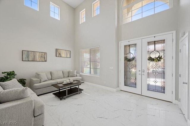 7012 Geese Gathering St, North Las Vegas, NV 89084 - living room featuring marble look tiles, a high ceiling, and french doors