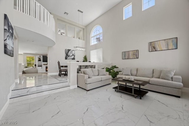 7012 Geese Gathering St, North Las Vegas, NV 89084 - living room with marble finish floors, a towering ceiling, and healthy amount of natural light
