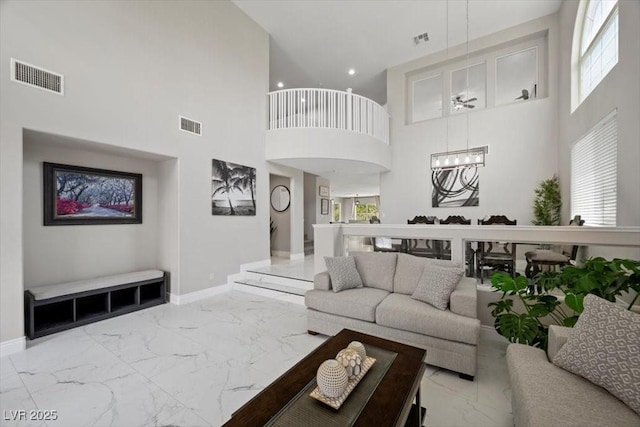 7012 Geese Gathering St, North Las Vegas, NV 89084 - living area featuring marble look tile flooring, a high ceiling, a chandelier, healthy amount of natural light, and recessed lighting
