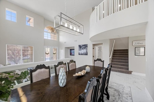7012 Geese Gathering St, North Las Vegas, NV 89084 - dining space with marble look tile flooring, a high ceiling, and stairs