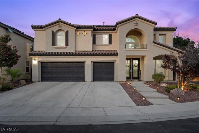7012 Geese Gathering St, North Las Vegas, NV 89084 - mediterranean / spanish home featuring a tiled roof, an attached garage, stucco siding, concrete driveway, and french doors