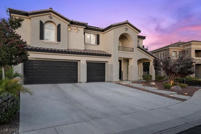 7012 Geese Gathering St, North Las Vegas, NV 89084 - mediterranean / spanish house featuring a tiled roof, an attached garage, concrete driveway, and stucco siding