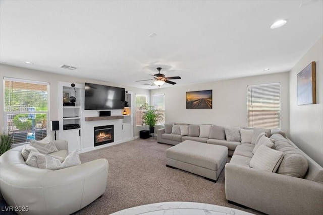 7012 Geese Gathering St, North Las Vegas, NV 89084 - living area with a large fireplace, ceiling fan, carpet floors, and recessed lighting