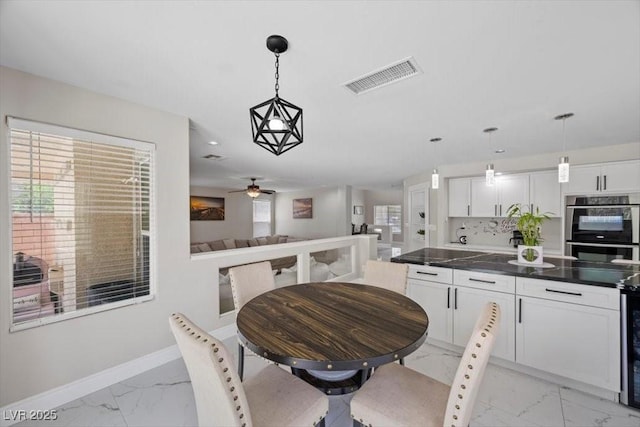 7012 Geese Gathering St, North Las Vegas, NV 89084 - dining space featuring light marble finish flooring, a ceiling fan, and beverage cooler