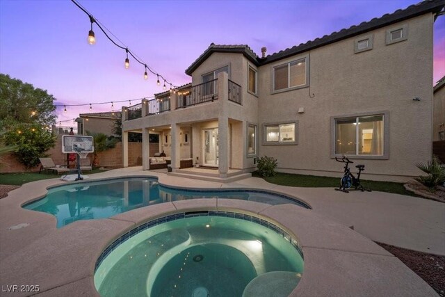 7012 Geese Gathering St, North Las Vegas, NV 89084 - pool at dusk with a patio area and a pool with connected hot tub