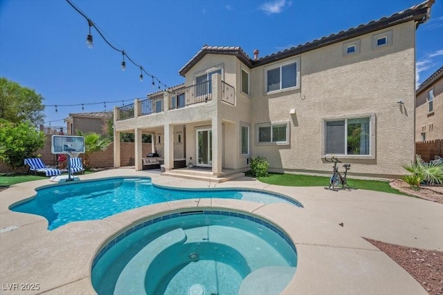 7012 Geese Gathering St, North Las Vegas, NV 89084 - rear view of property featuring a balcony, stucco siding, a patio area, and a pool with connected hot tub