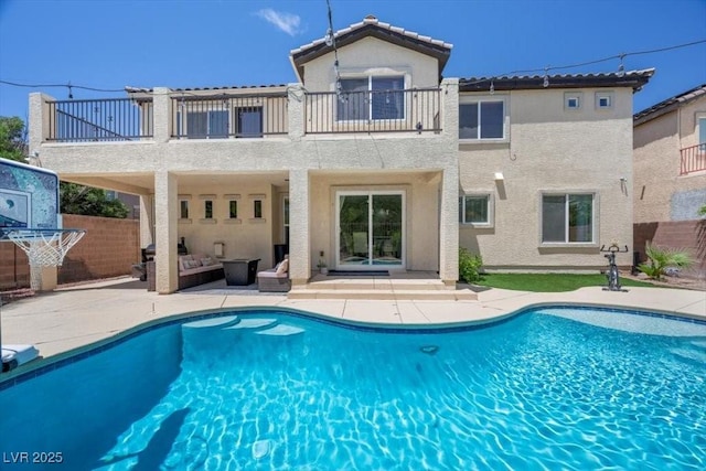 7012 Geese Gathering St, North Las Vegas, NV 89084 - rear view of property with a balcony, stucco siding, a patio, and an outdoor pool