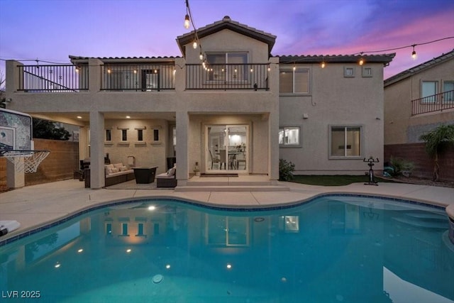 7012 Geese Gathering St, North Las Vegas, NV 89084 - rear view of property with a balcony, a patio, stucco siding, and an outdoor pool