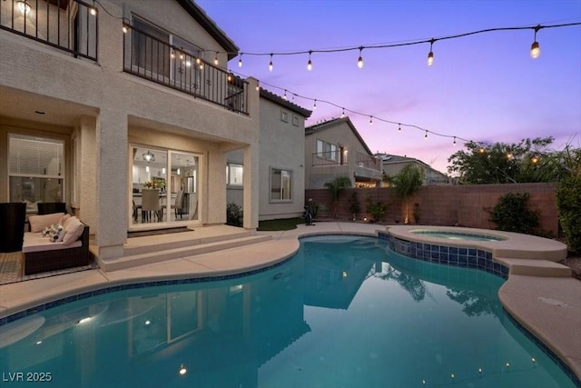 7012 Geese Gathering St, North Las Vegas, NV 89084 - pool at dusk with a fenced backyard, a patio, and a pool with connected hot tub