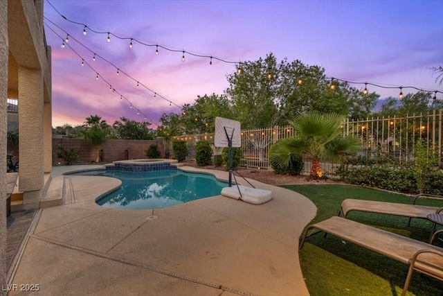 7012 Geese Gathering St, North Las Vegas, NV 89084 - pool at dusk with a fenced backyard, a patio area, and a pool with connected hot tub