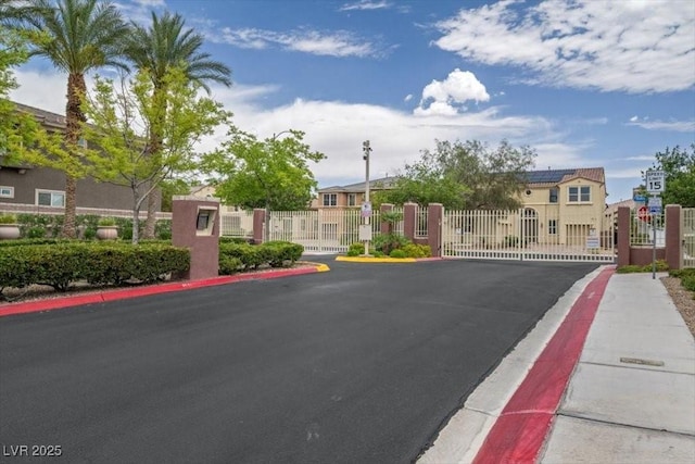 7012 Geese Gathering St, North Las Vegas, NV 89084 - view of asphalt street featuring a gate, curbs, a gated entry, and sidewalks