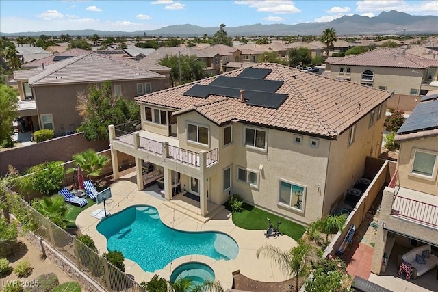 7012 Geese Gathering St, North Las Vegas, NV 89084 - back of house featuring a balcony, a fenced backyard, a residential view, solar panels, and a patio area