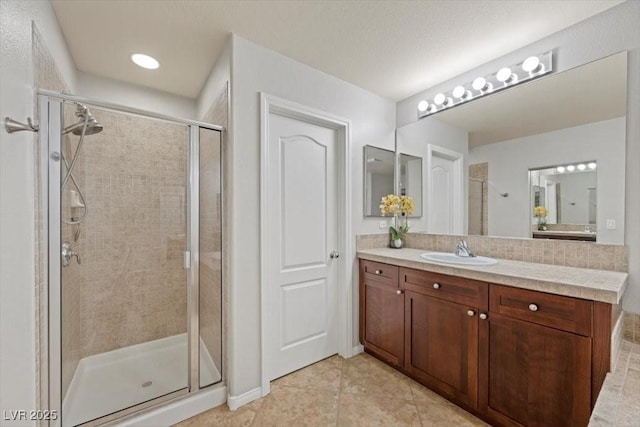 7012 Geese Gathering St, North Las Vegas, NV 89084 - bathroom with a shower stall, vanity, tile patterned floors, and decorative backsplash
