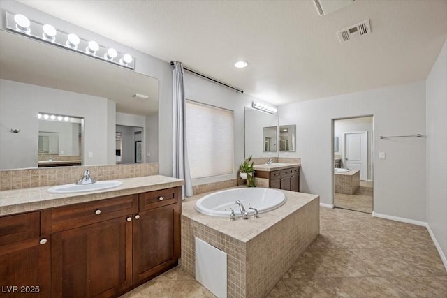 7012 Geese Gathering St, North Las Vegas, NV 89084 - full bathroom with two vanities, a garden tub, backsplash, and tile patterned floors