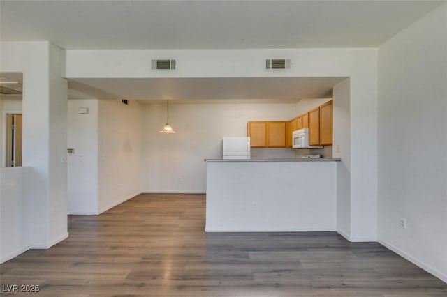 2030 Rancho Lake Dr Unit 201, Las Vegas, NV 89108 - kitchen featuring white microwave, fridge, dark wood finished floors, and a peninsula