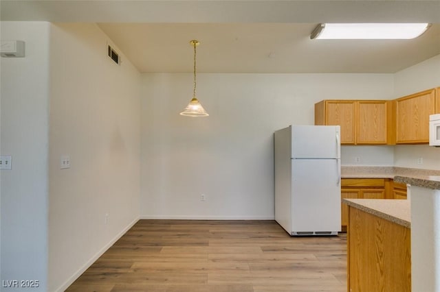 2030 Rancho Lake Dr Unit 201, Las Vegas, NV 89108 - kitchen featuring white appliances, light wood finished floors, light countertops, decorative light fixtures, and light brown cabinetry