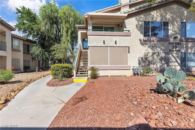 5710 E Tropicana Ave Unit 2152, Las Vegas, NV 89122 - view of front of home with stairway, stucco siding, a balcony, and a tile roof
