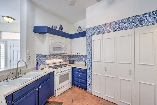 4770 Big Draw Dr, North Las Vegas, NV 89031 - kitchen with white appliances, blue cabinetry, tasteful backsplash, light countertops, and light tile patterned floors