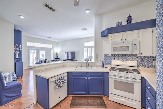 4770 Big Draw Dr, North Las Vegas, NV 89031 - kitchen with white appliances, open floor plan, blue cabinetry, a peninsula, and light countertops
