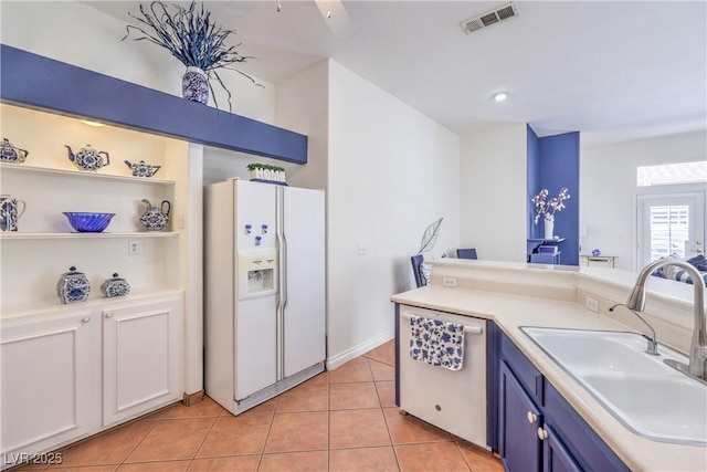 4770 Big Draw Dr, North Las Vegas, NV 89031 - kitchen featuring white refrigerator with ice dispenser, blue cabinets, stainless steel dishwasher, light tile patterned flooring, and light countertops