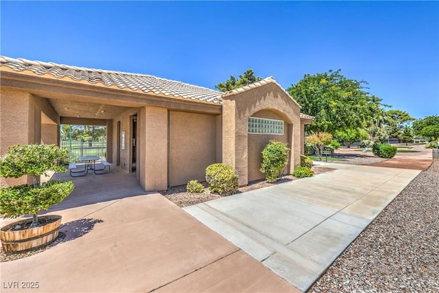 4770 Big Draw Dr, North Las Vegas, NV 89031 - view of property exterior with stucco siding, a tiled roof, and a patio