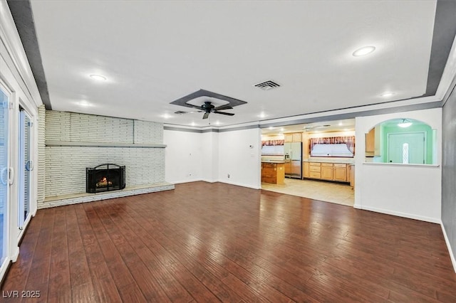 1885 Valley Dr, Las Vegas, NV 89108 - unfurnished living room featuring a ceiling fan, light wood-style flooring, a fireplace, recessed lighting, and arched walkways