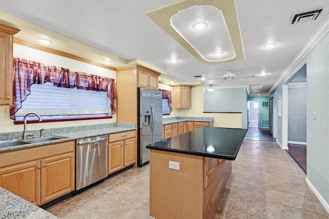 1885 Valley Dr, Las Vegas, NV 89108 - kitchen featuring appliances with stainless steel finishes, ornamental molding, ceiling fan, a center island, and a textured ceiling
