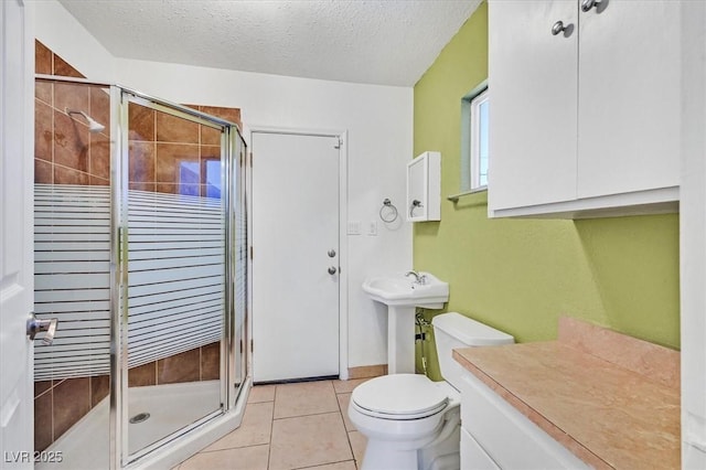 1885 Valley Dr, Las Vegas, NV 89108 - full bath featuring a shower stall, tile patterned floors, and a textured ceiling