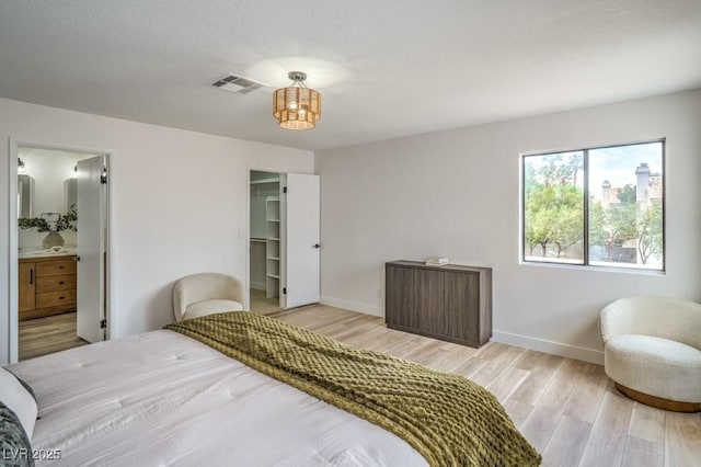 10009 Coral Sands Dr, Las Vegas, NV 89117 - bedroom featuring light wood-type flooring, ensuite bathroom, and a walk in closet