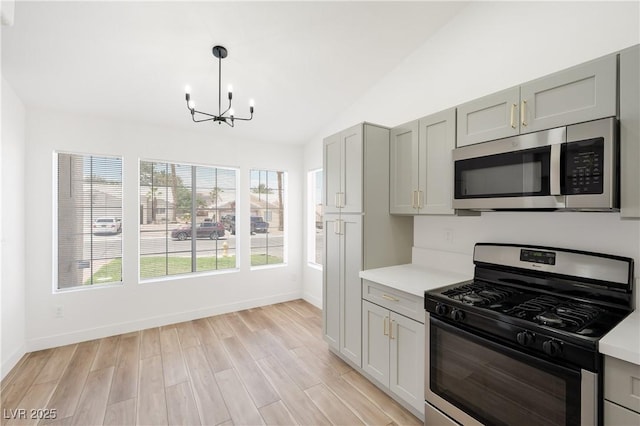 3622 Covewick Dr, North Las Vegas, NV 89032 - kitchen featuring appliances with stainless steel finishes, a chandelier, light countertops, gray cabinets, and vaulted ceiling