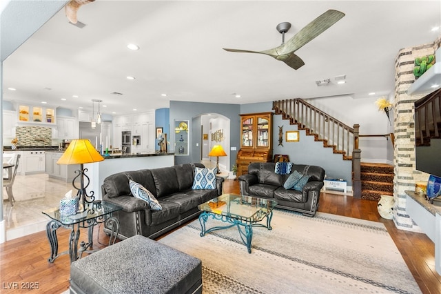 7428 Doe Ave, Las Vegas, NV 89117 - living area featuring a ceiling fan, stairway, light wood-style flooring, arched walkways, and recessed lighting